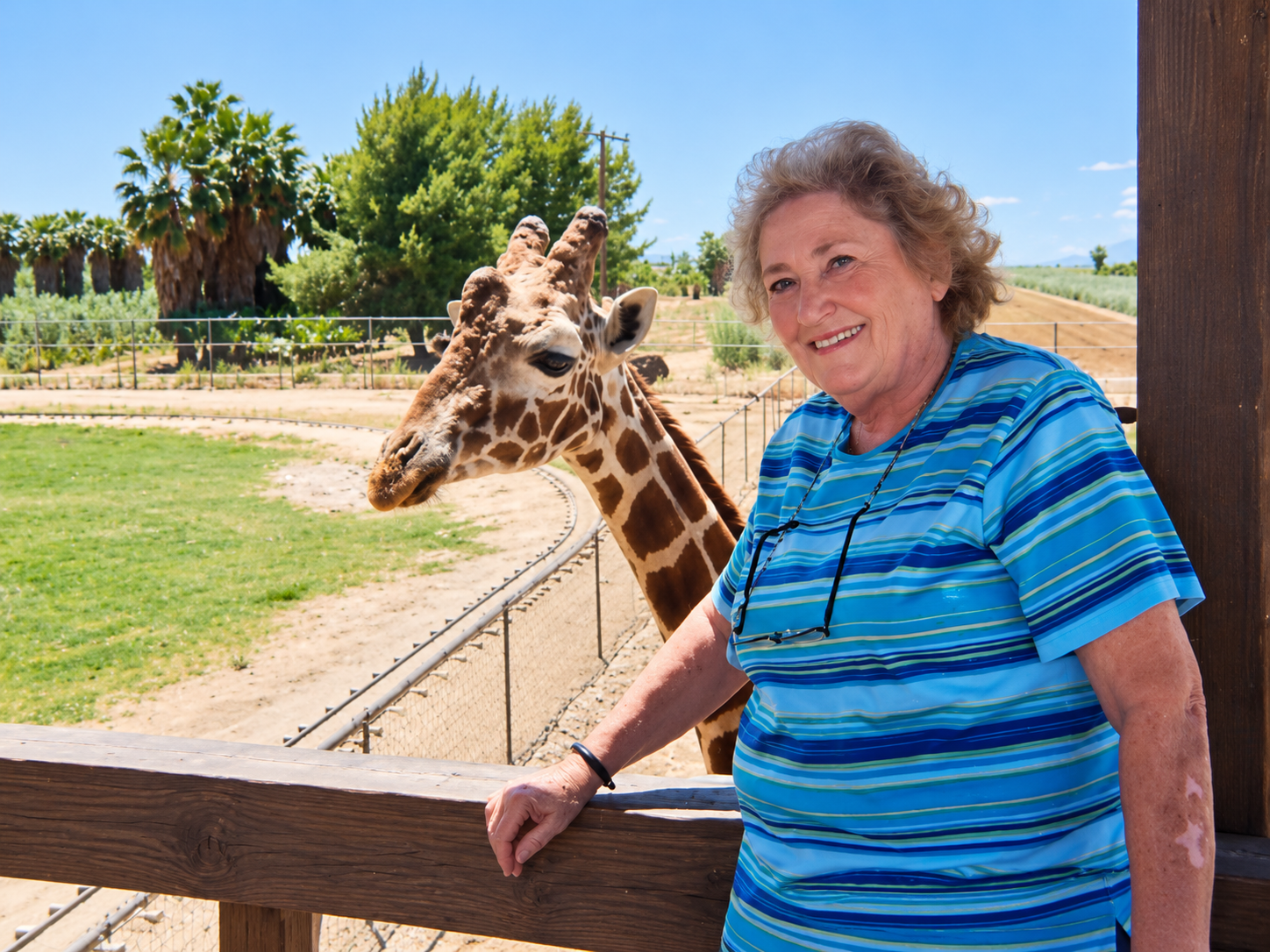 A woman smiling beside a giraffe at an Arizona wildlife park